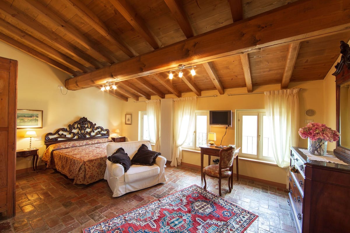 Une pièce confortable avec un lit, un canapé, un bureau et une commode.