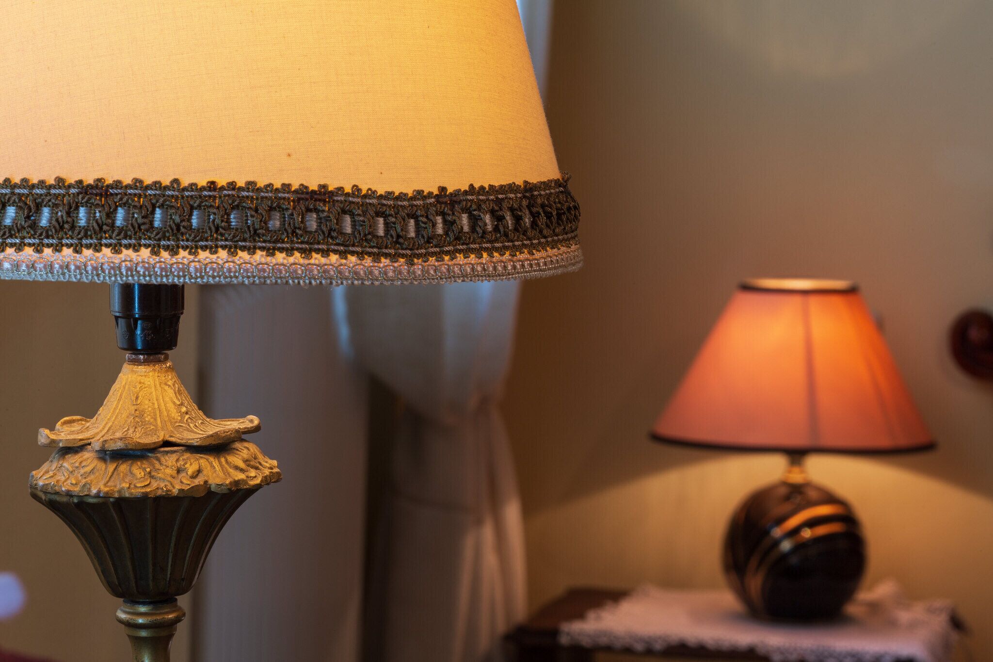 A close-up of a lamp with a decorative base and a fabric shade.