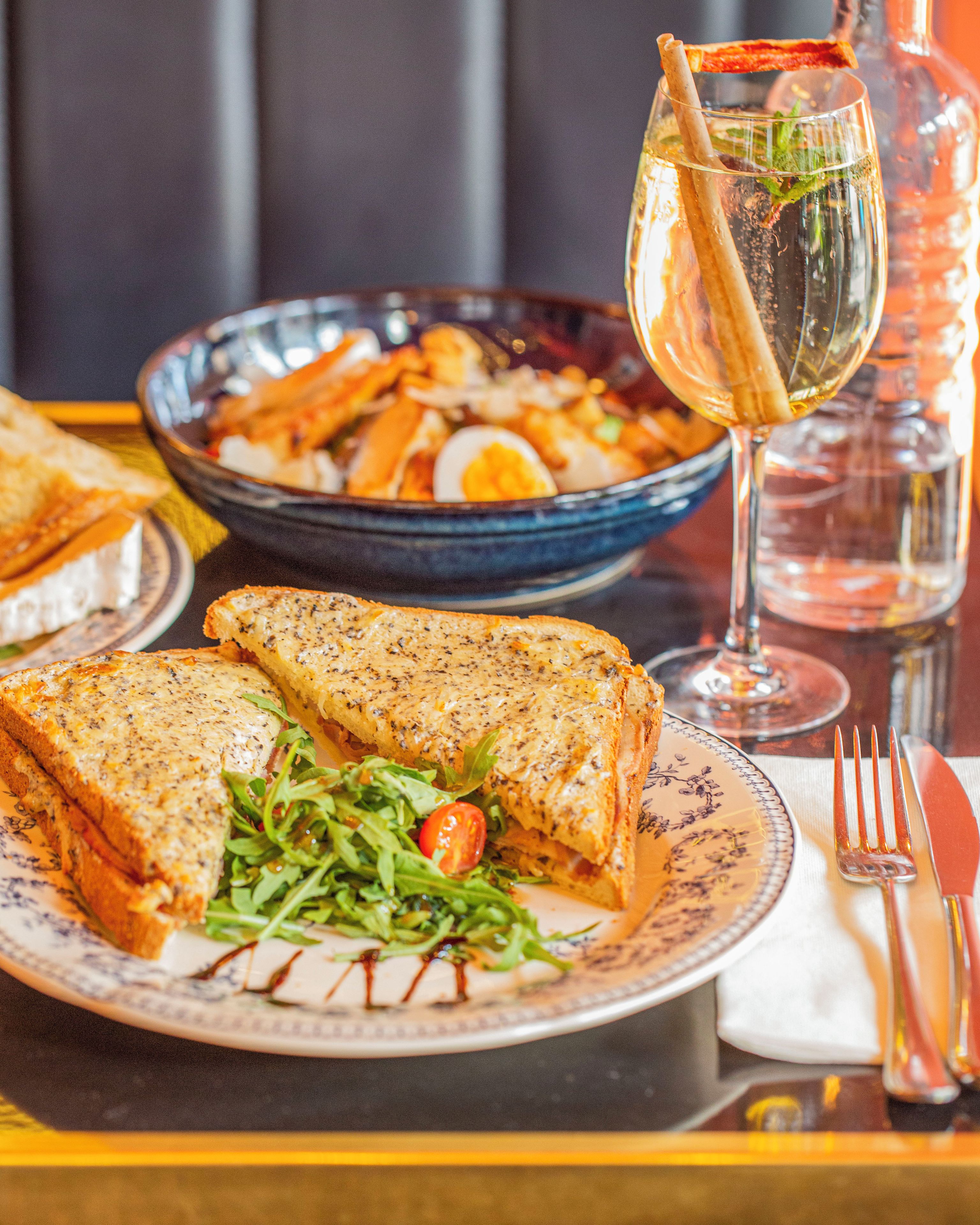 A meal consisting of a sandwich, salad, and a bowl of fries.