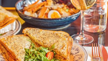 A meal consisting of a sandwich, salad, and a bowl of fries.
