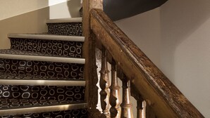 A wooden staircase with patterned steps and a handrail. - Hôtel Georgette (Paris)