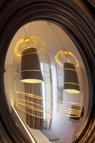 Vista circular de una habitación con dos lámparas colgantes y una ventana con cortinas.