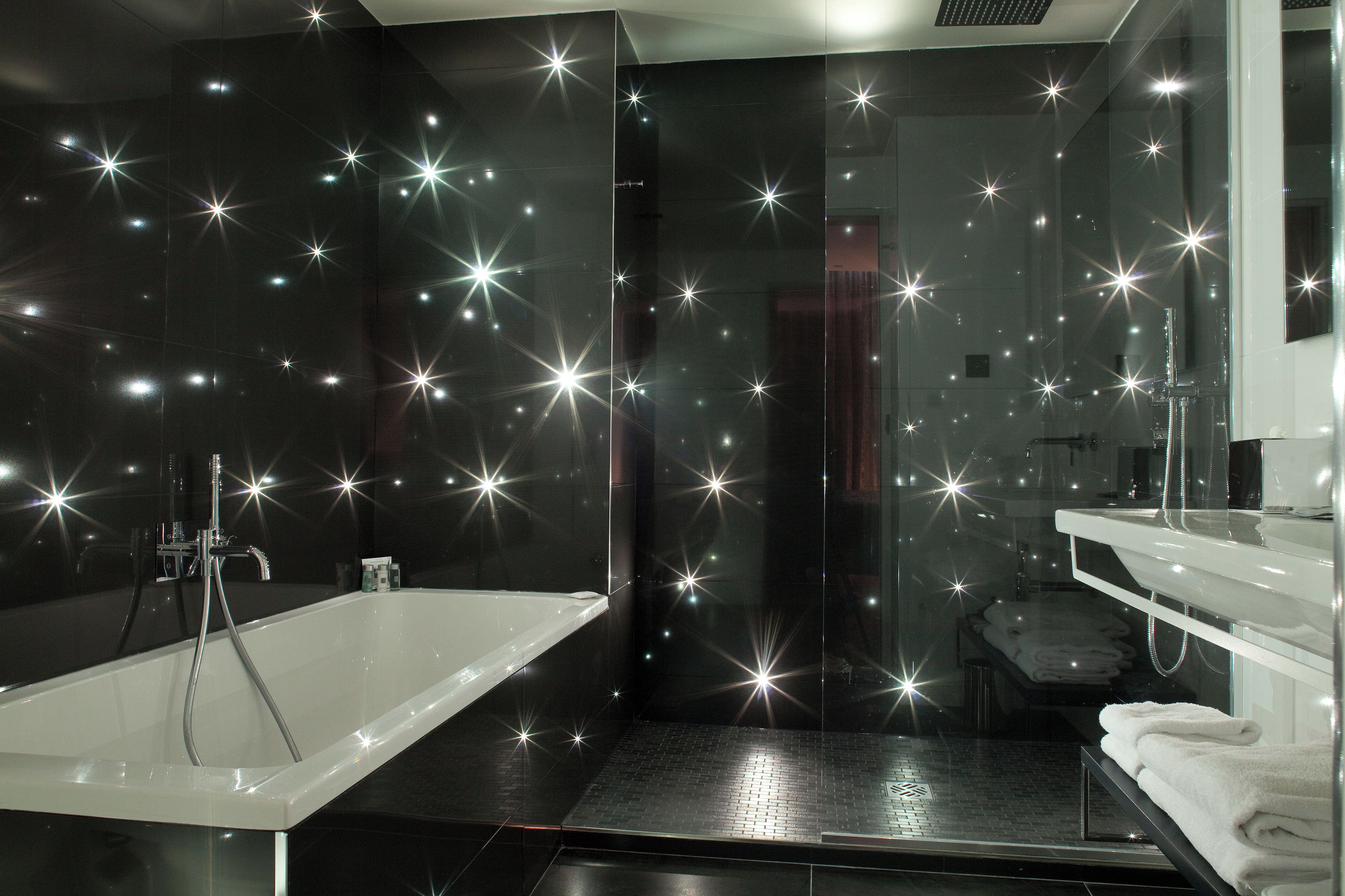 A modern bathroom with a bathtub, a glass shower enclosure, and a vanity with a mirror.