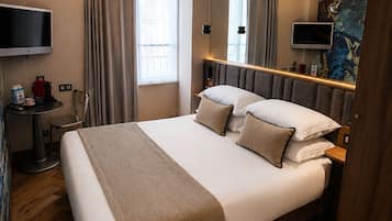 Een moderne hotelkamer met een groot bed, een bureau met stoel, een flatscreen televisie en een groot raam met gordijnen.
