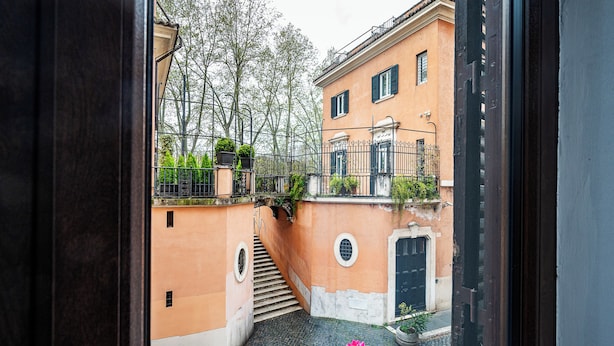 Une ruelle étroite avec un escalier menant à un immeuble doté d’un balcon.