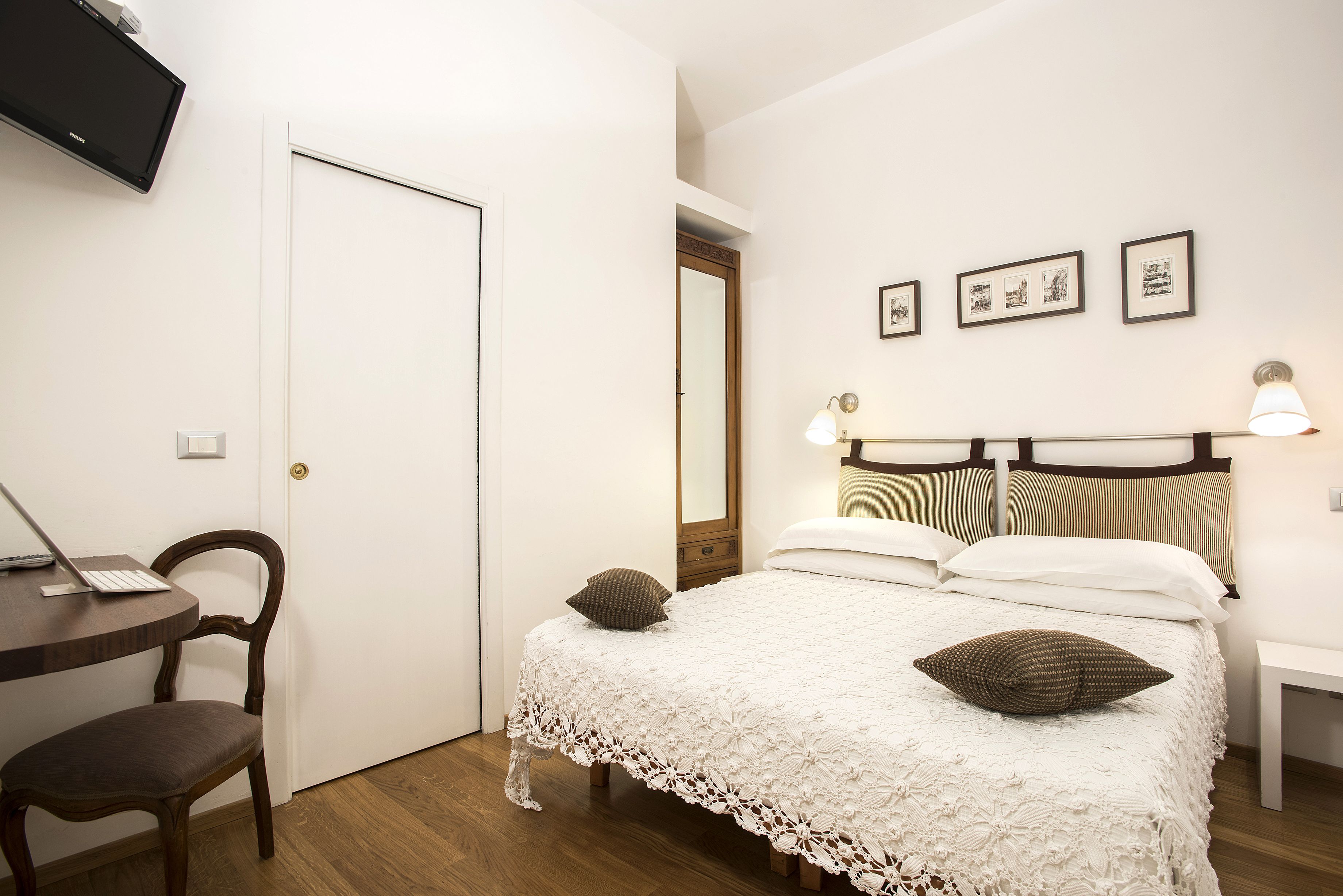 Um quarto com uma cama, uma escrivaninha e uma cadeira.