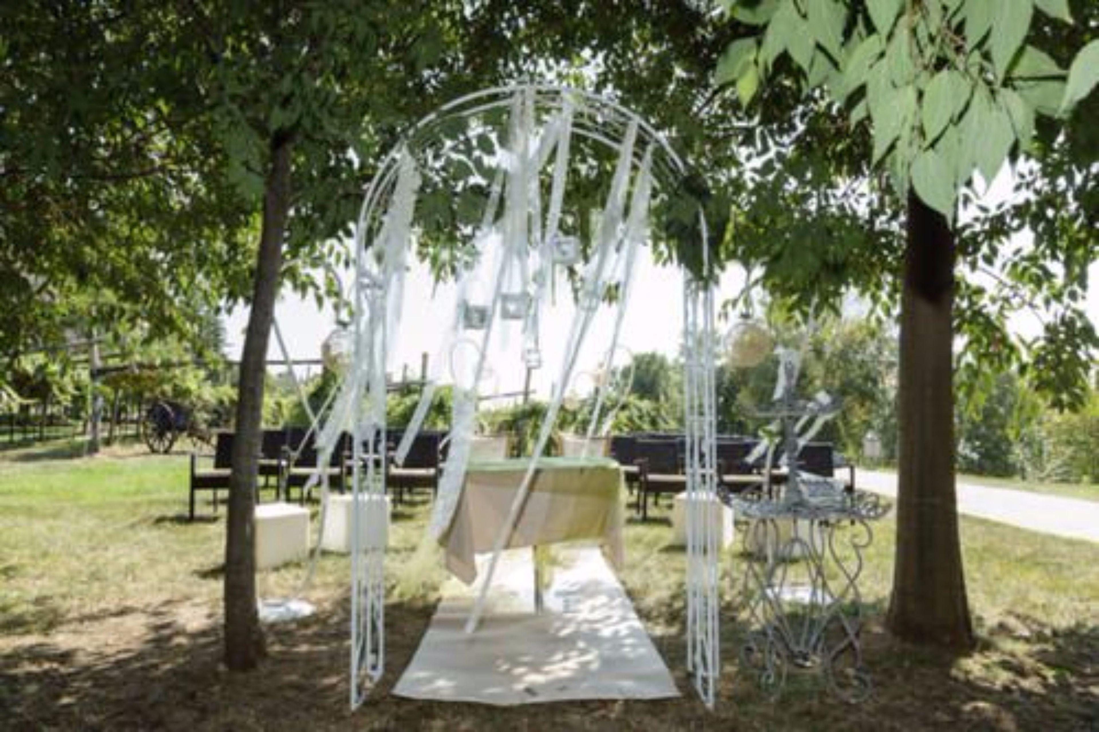 A gazebo with a table and chairs in a park setting.