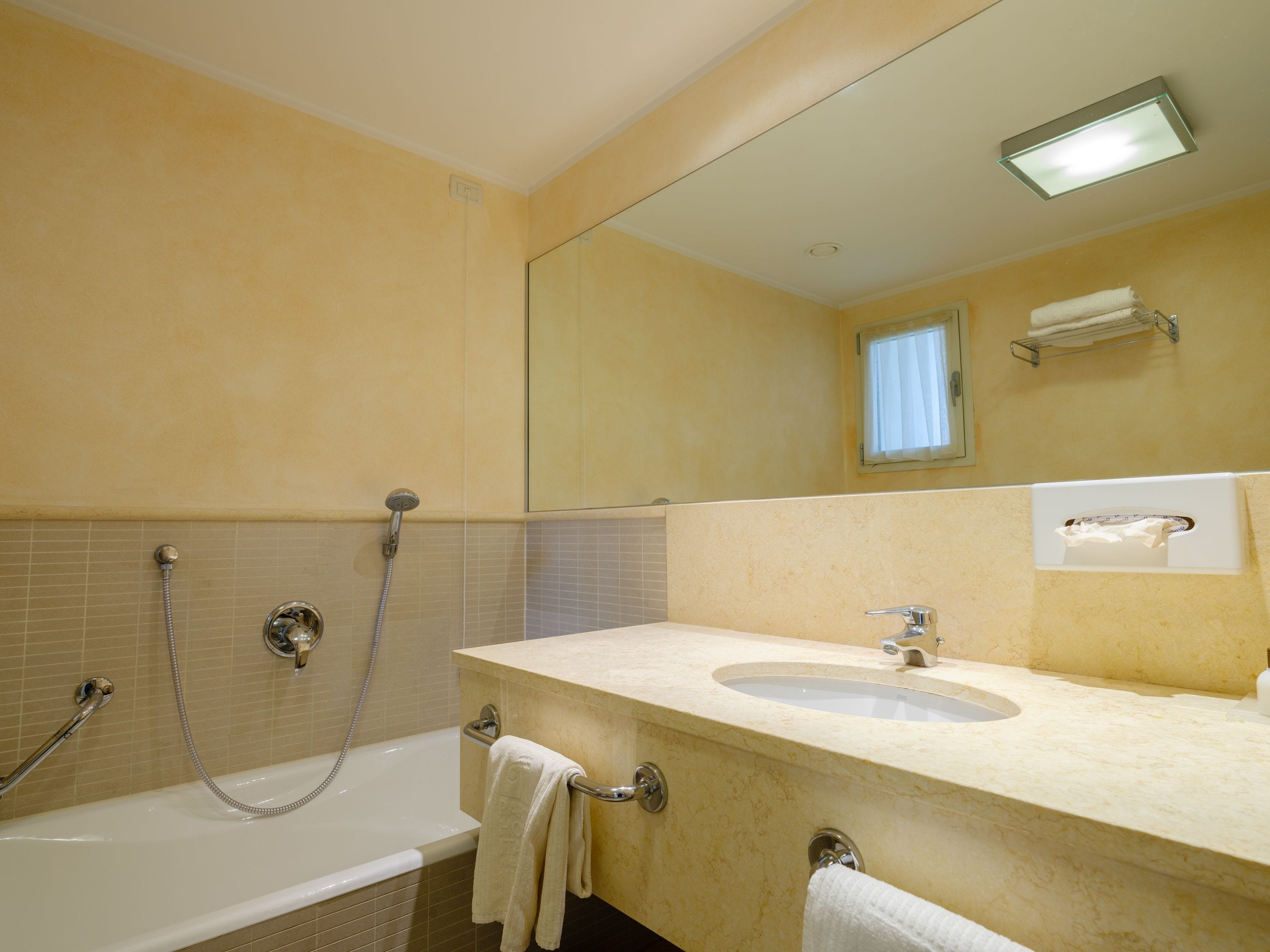 Un baño con bañera, lavamanos y espejo.