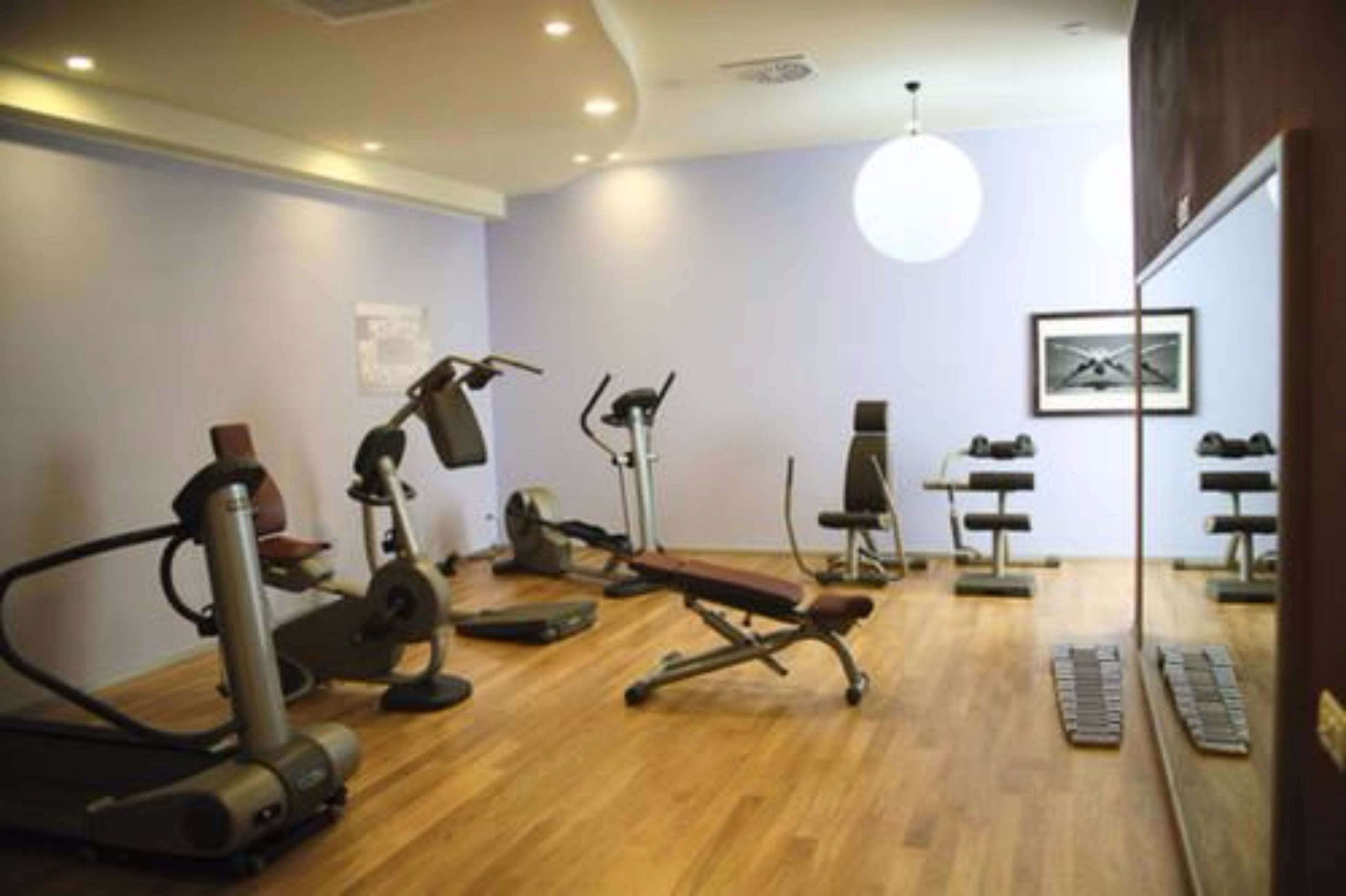 A gym with various exercise equipment, including a treadmill, stationary bike, and weight machines.