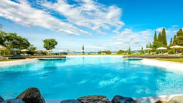 Una piscina techada, una piscina al aire libre de temporada, sombrillas