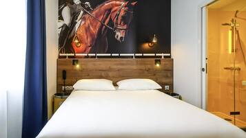 Habitación de hotel con una cama grande, cabecero de madera, dos mesitas de noche con lámparas y un cuadro grande de un caballo en la pared.
