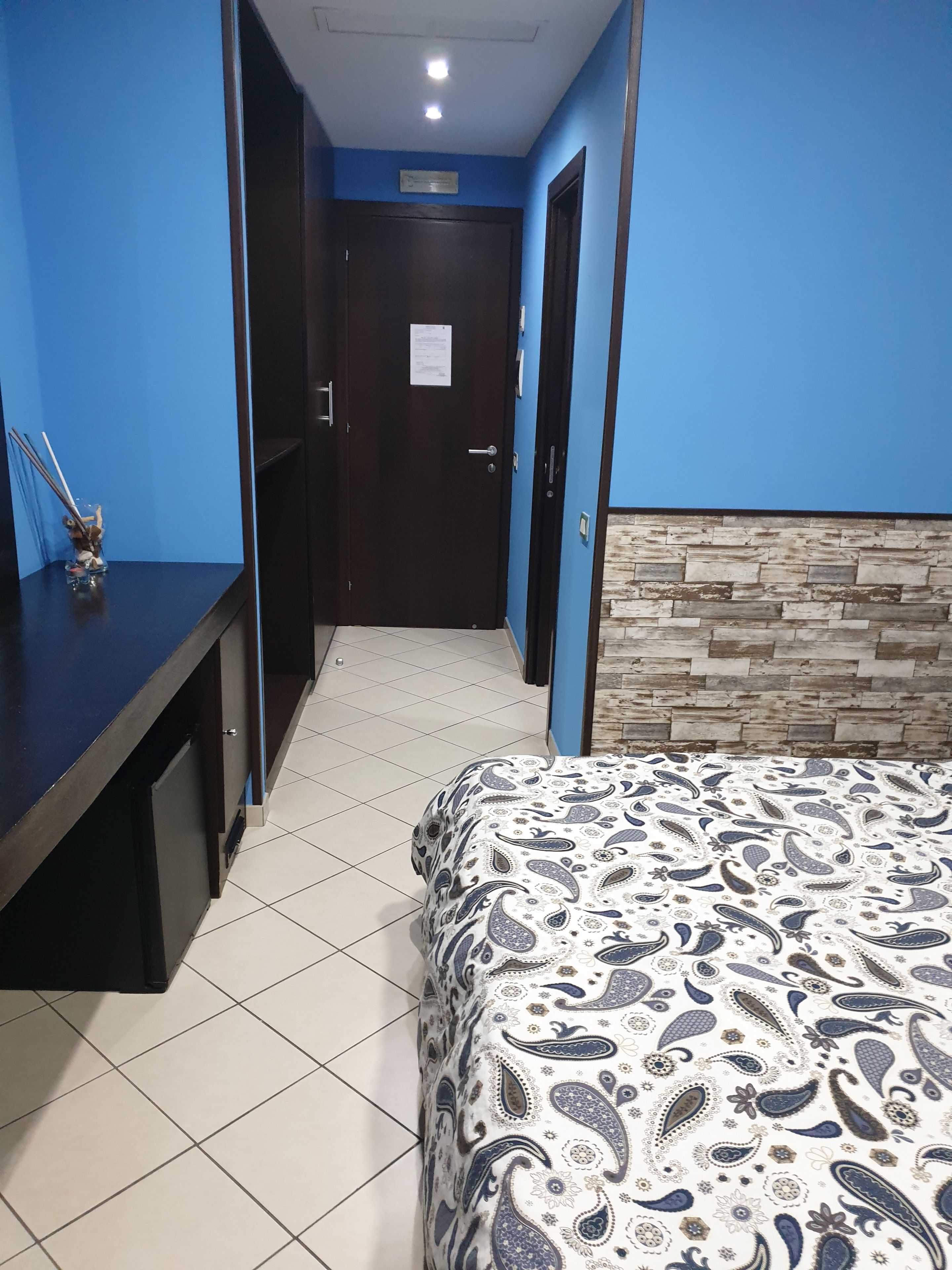 Une chambre d’hôtel avec un lit, un bureau et une porte.