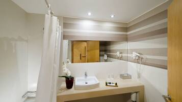 A modern bathroom with a sink, mirror, and shower curtain.