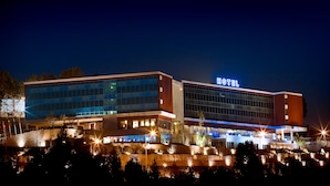 A modern hotel with a prominent "HOTEL" sign, large glass windows, and a well-lit facade. - Penafiel Park Hotel & Spa (Penafiel)