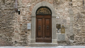 A stone building with a wooden double door, a number '8' sign, and a plaque. - Numa Florence Palazzo Belfiore (Florence)