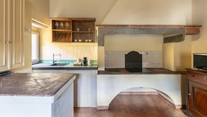 A kitchen with a built-in oven, a sink, and a wooden shelf above the counter. - Numa Florence Palazzo Belfiore (Florence)
