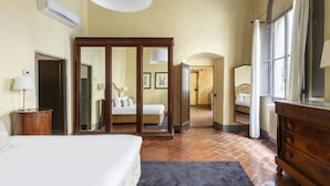 A spacious bedroom with a large bed, a wardrobe, and a mirror. - Numa Florence Palazzo Belfiore (Florence)