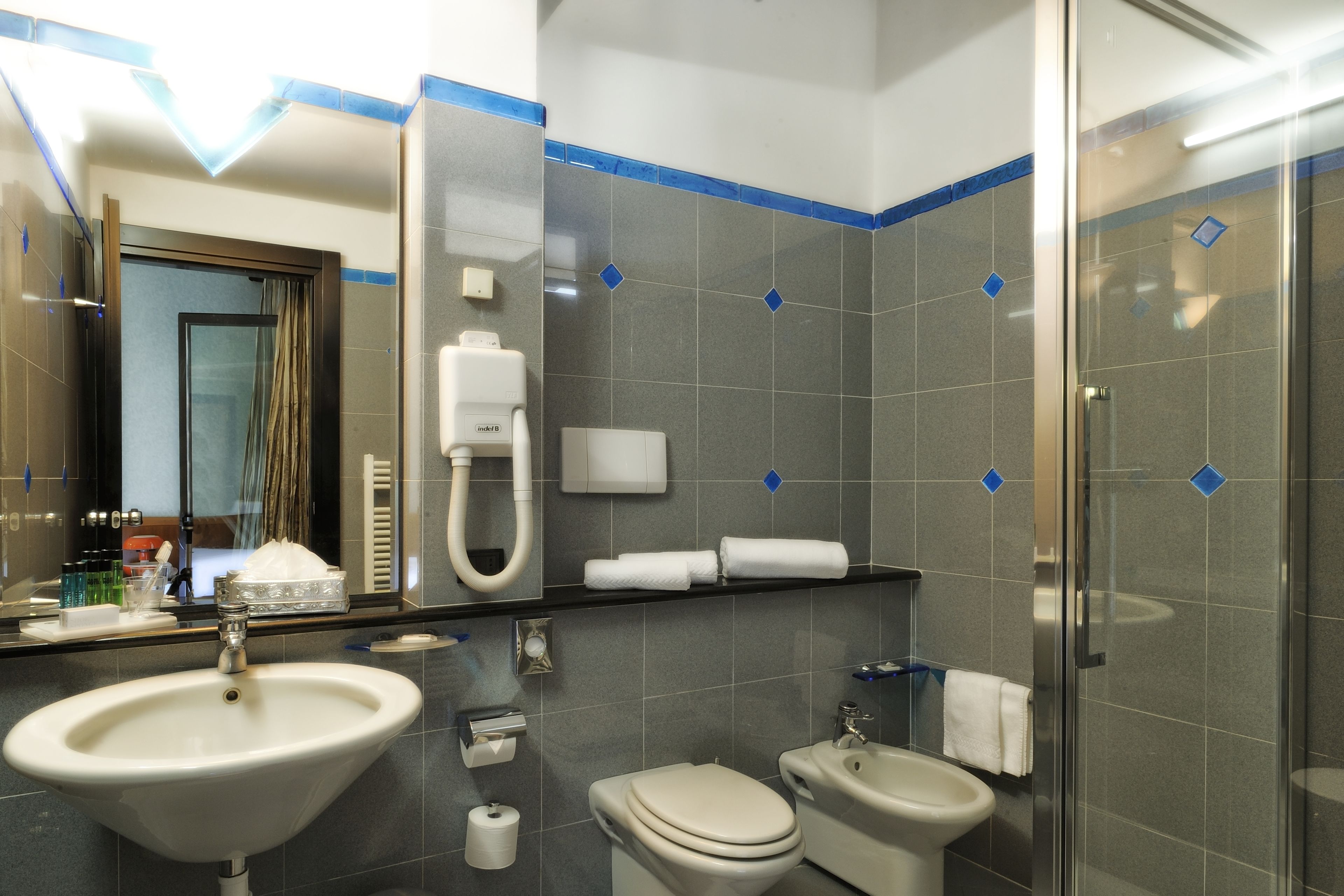 A modern bathroom with a sink, toilet, and shower.