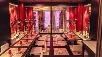 Une chambre d’hôtel avec un grand lit, une table de chevet et une fenêtre avec des rideaux.