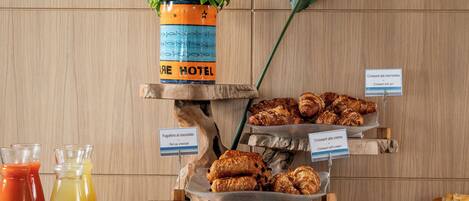 Ein Frühstücksbuffet mit Croissants, Gebäck und Saft.