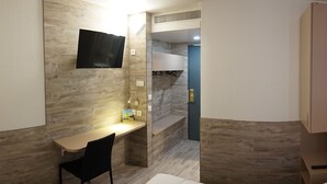 A modern bathroom with a wooden vanity, a sink, and a mirror. There is a shower area with a glass door and a towel rack. - Logis Hôtel Acotel (Le Pontet)