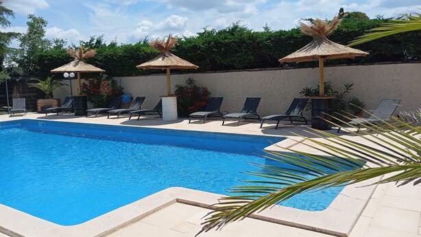 A swimming pool with lounge chairs and thatched umbrellas. - Logis Hôtel Acotel (Le Pontet)