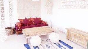 A cozy living room with a sofa, a wooden coffee table, and decorative macramé wall hangings. - Residence Maresol (Vieste)