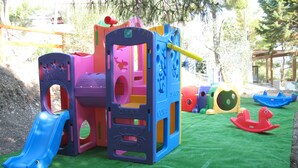 A children's play structure with slides and climbing areas, set on artificial grass. - Residence Maresol (Vieste)