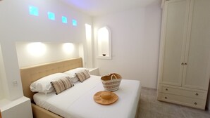 A bedroom with a bed, pillows, a hat, a basket, and a wardrobe. - Residence Maresol (Vieste)