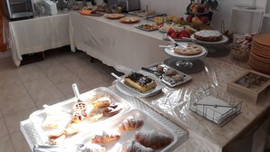 A buffet table with various food items and a juice dispenser. - Residence Maresol (Vieste)
