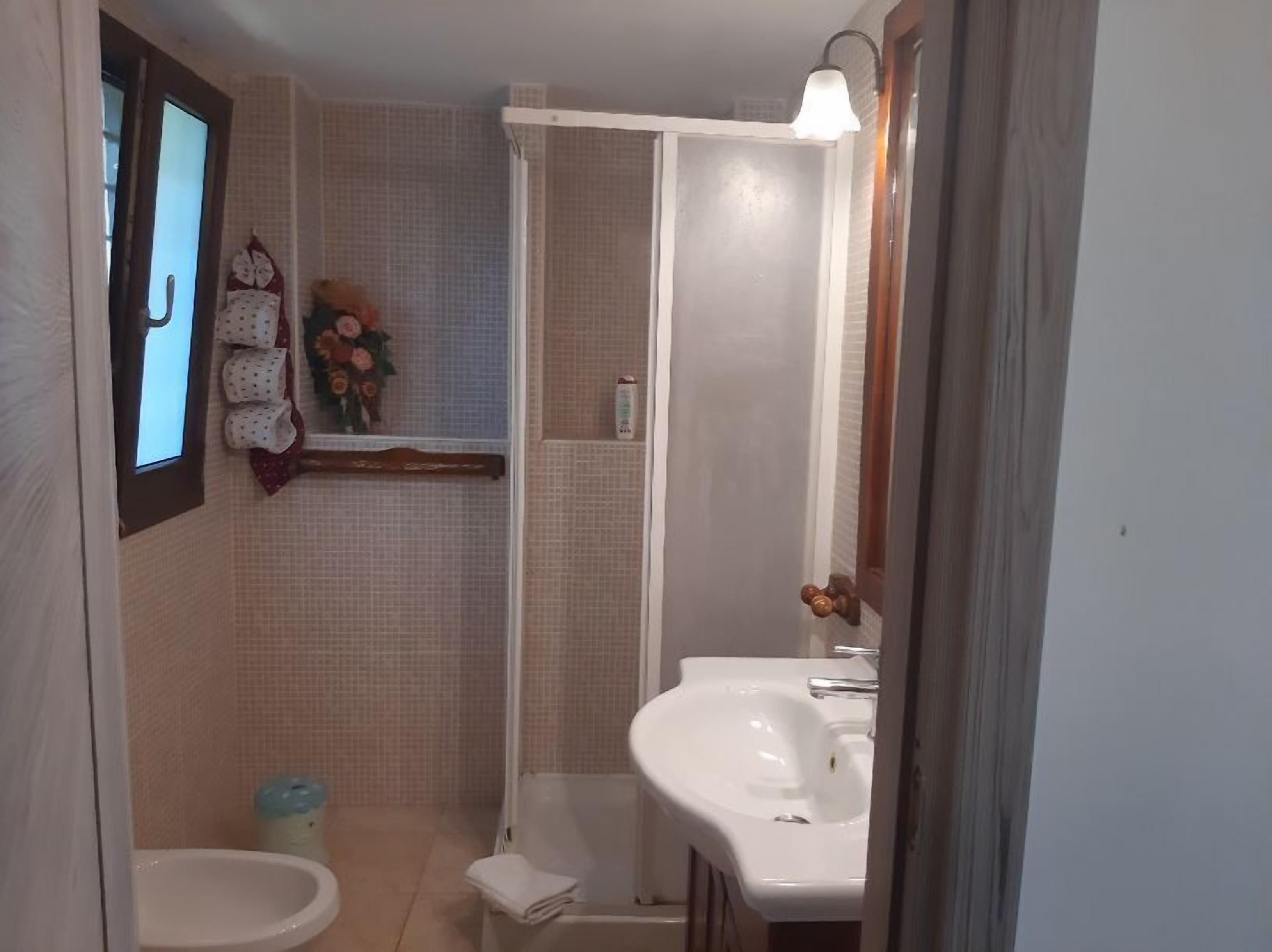 Ein Badezimmer mit Toilette, Bidet, Waschbecken und Dusche.