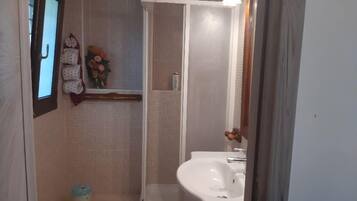 Ein Badezimmer mit Toilette, Bidet, Waschbecken und Dusche.