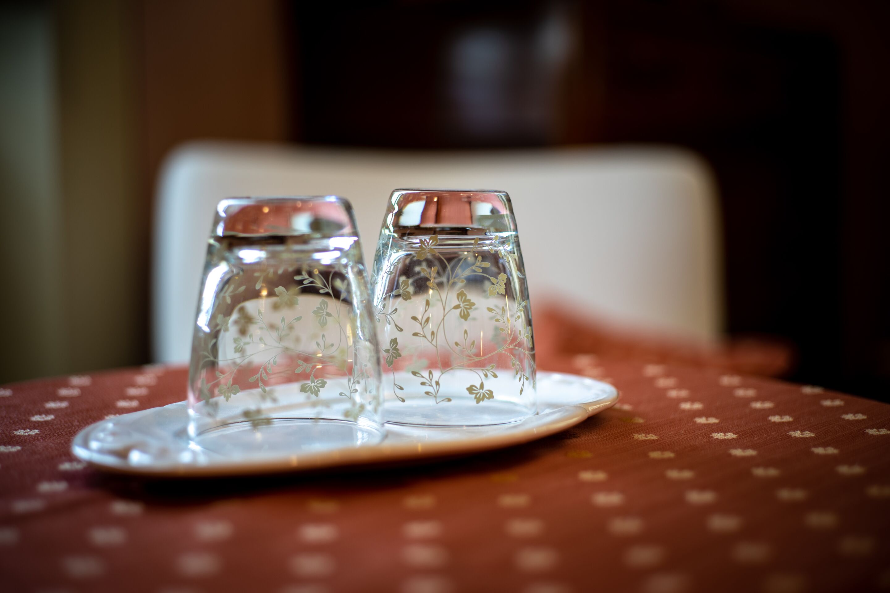 Two salt and pepper shakers on a table with a polka dot tablecloth.