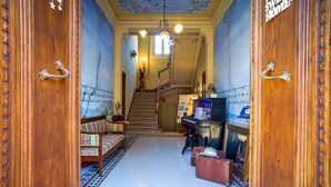 A grand hallway with a staircase, a piano, and a bench. - Marta Guest House (Lucca)