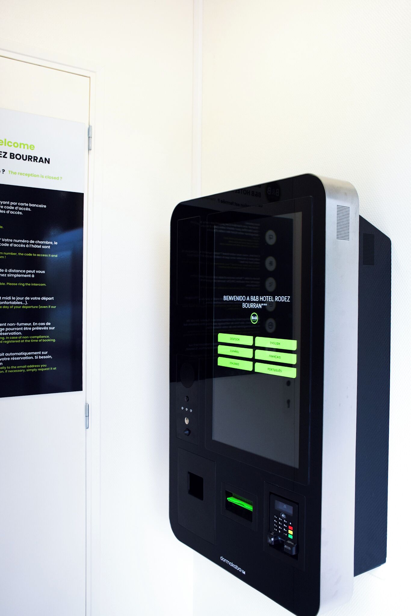 A self-service kiosk with a digital display and a keypad, likely for room access or information.