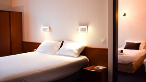 Ein Hotelzimmer mit einem großen Bett, zwei Nachttischen und einem Kleiderschrank.