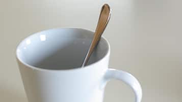 Una taza de cerámica blanca con una cuchara dentro.