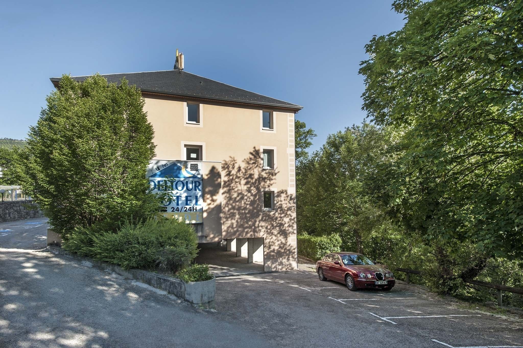 A two-story building with a sign advertising a tour hotel.