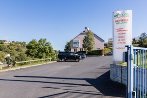 Señal de BRIT HOTEL que indica servicios como alojamiento para 1 a 4 personas, WiFi gratuito, Canal+ y aceptación de tarjetas de crédito las 24 horas.