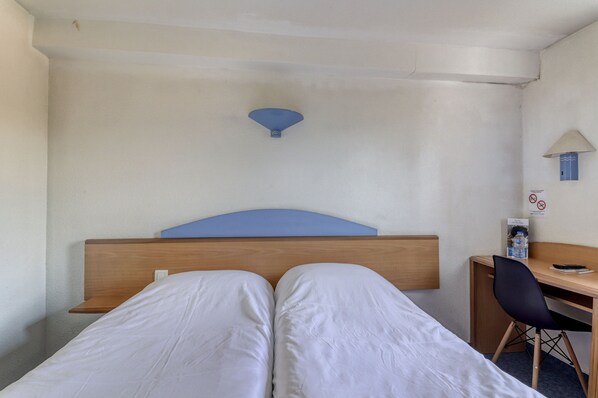 A hotel room with a bed, a desk, and a chair. - Brit Hotel Essentiel St Flour (Saint-Flour)