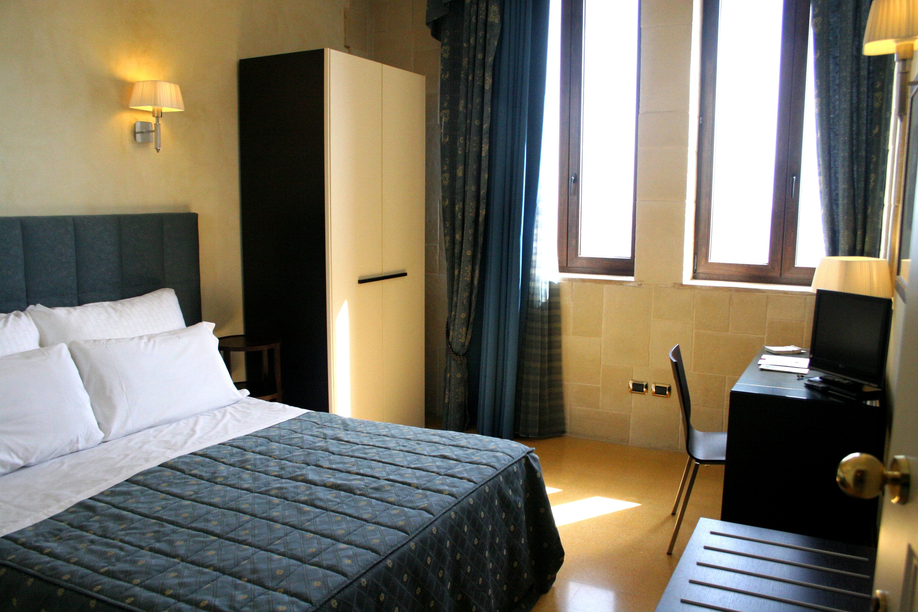 Ein Hotelzimmer mit einem Bett, einem Schreibtisch und einem Kleiderschrank.
