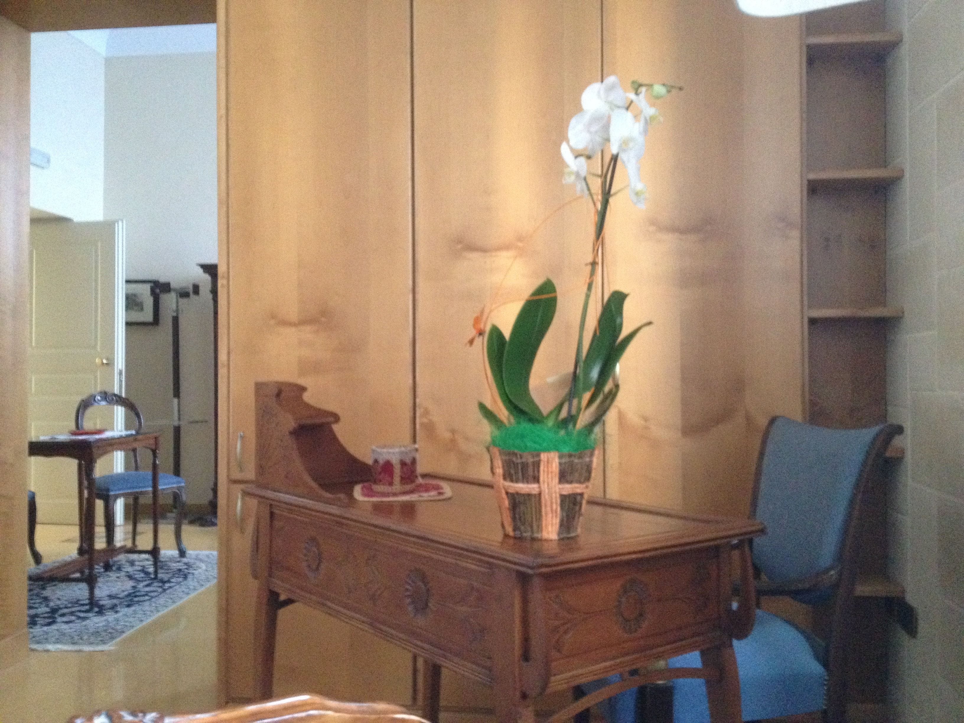 A wooden table with a potted plant and a small decorative item.
