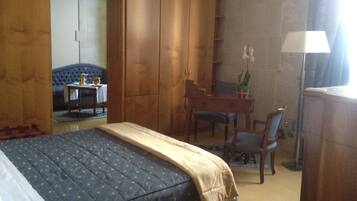 Ein Schlafzimmer mit Bett, Schreibtisch, Stuhl und Kleiderschrank.