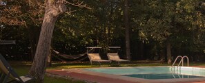 A swimming pool with two lounge chairs and a hammock. - Podere Violino (Sansepolcro)