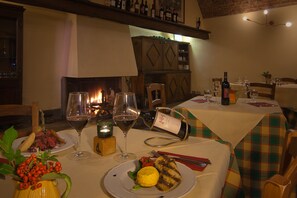 A dining table set for four with wine glasses, plates of food, and a candle. - Podere Violino (Sansepolcro)