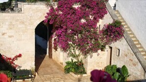 A stone pathway leading to a white building with a staircase. - Masseria Morrone (Ostuni)