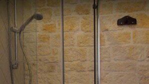 A shower with a glass door, a metal handle, and a towel rack. - Masseria Morrone (Ostuni)