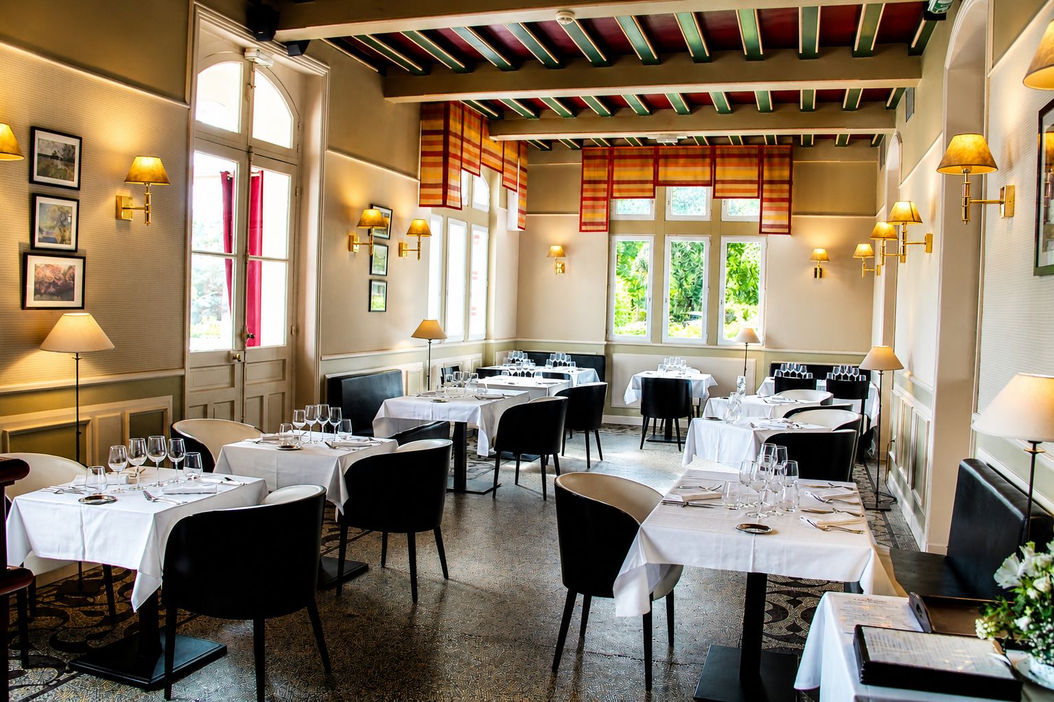 Restaurante com várias mesas, cadeiras e teto com vigas aparentes.