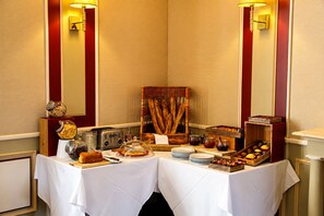 Montaje de un bufé de desayuno con diferentes alimentos y un tostador.