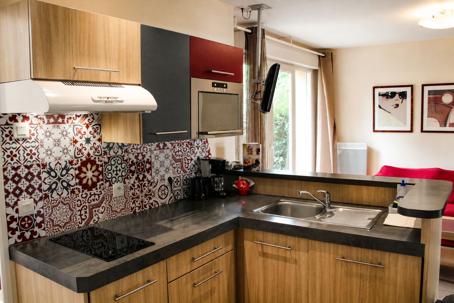 A compact kitchen with a built-in stove, a coffee maker, and a sink.